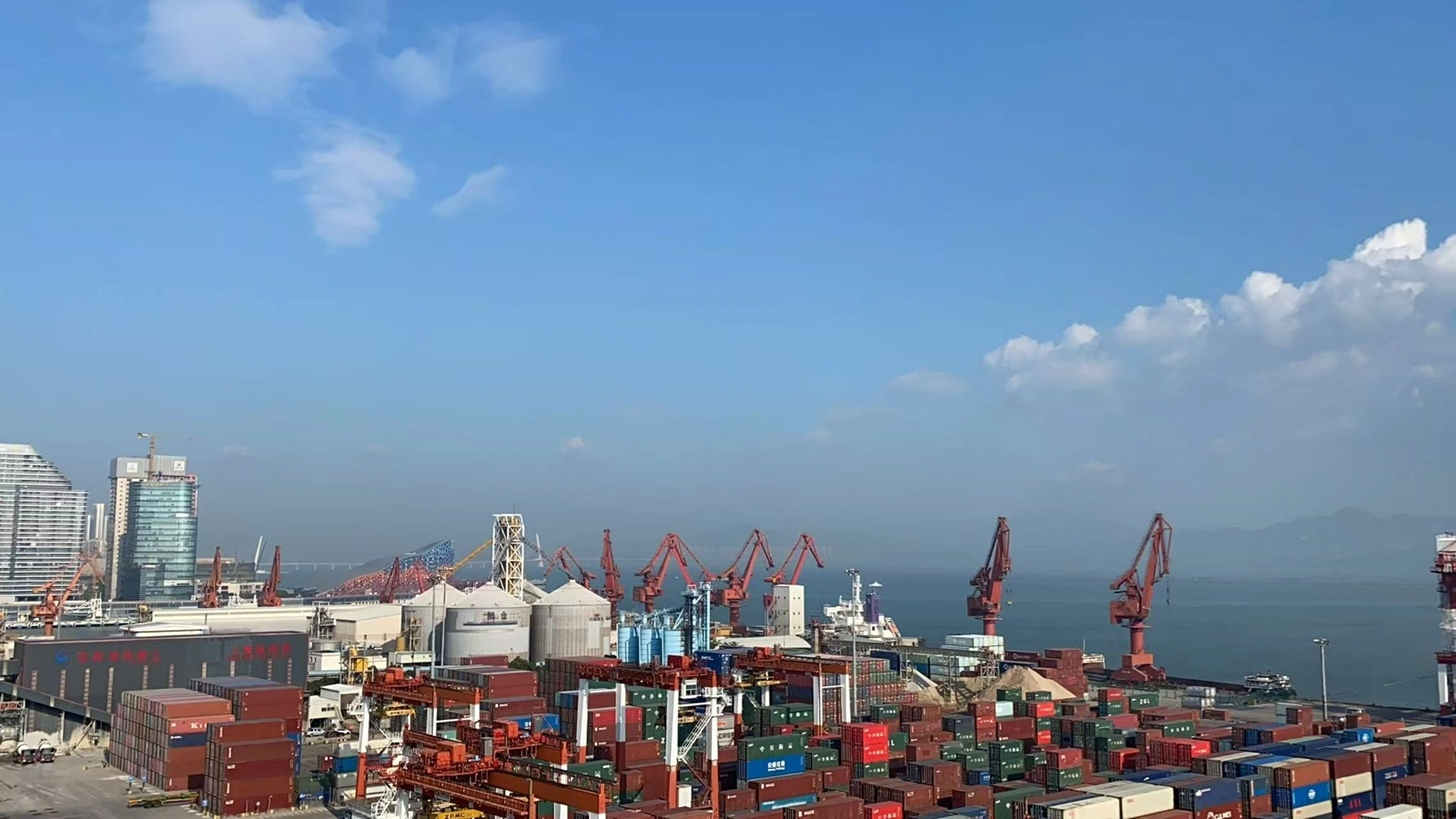 Busy container terminal with cranes and stacked containers during peak shipping operations