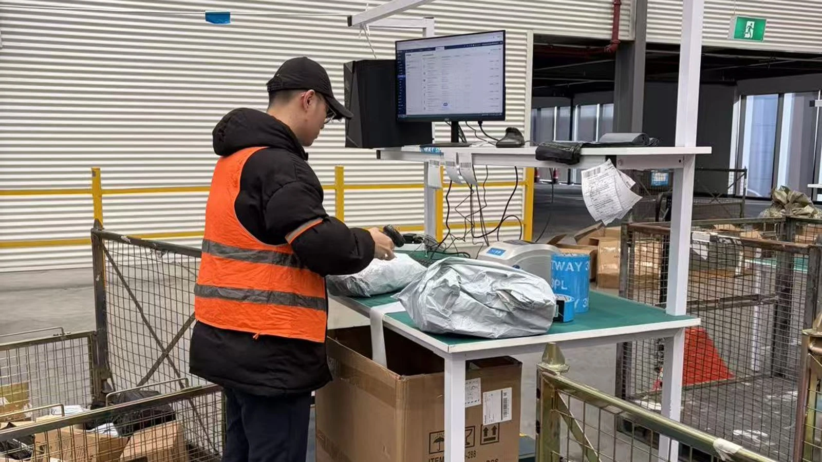 Warehouse worker scanning carton labels during Amazon FBA shipment preparation in China